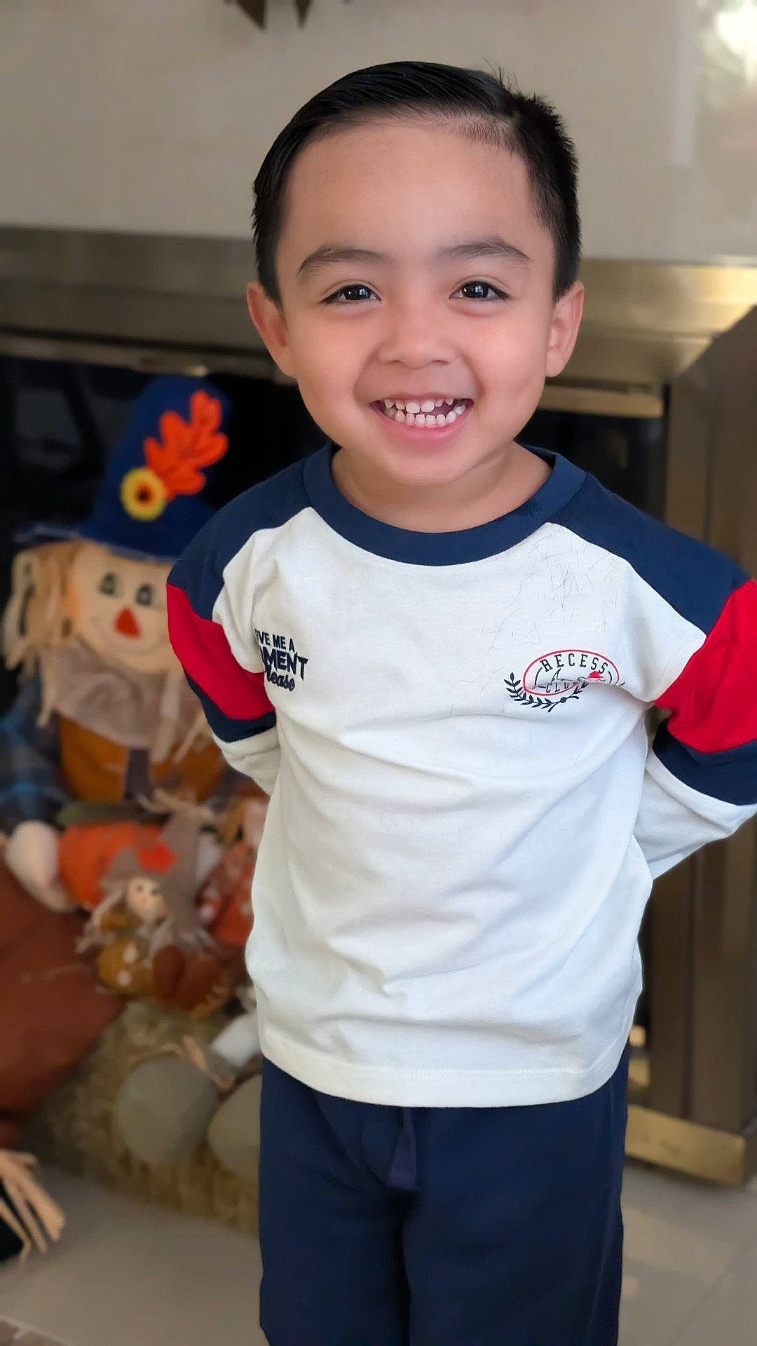 Andrew joined the competition — help win amazing prizes! boy, child, clothing, colorful, front_facing, furniture, happy, home, indoors, living_room, photograph, playroom, portrait, short_hair, smiling, standing, stuffed_animals, teeth, toy, tshirt