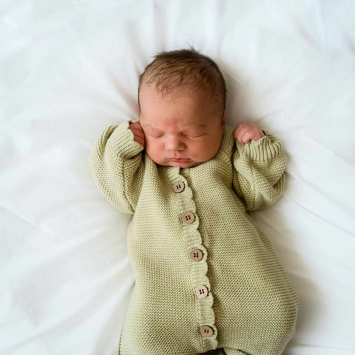 Paul is registered to the contest to win money with this photo: baby, blanket, child, cozy, cute, green_onesie, human, indoors, infant, knitted_clothing, lying_down, newborn, peaceful, portrait, relaxed, sleeping, small, soft_texture, tiny_feet, white_background