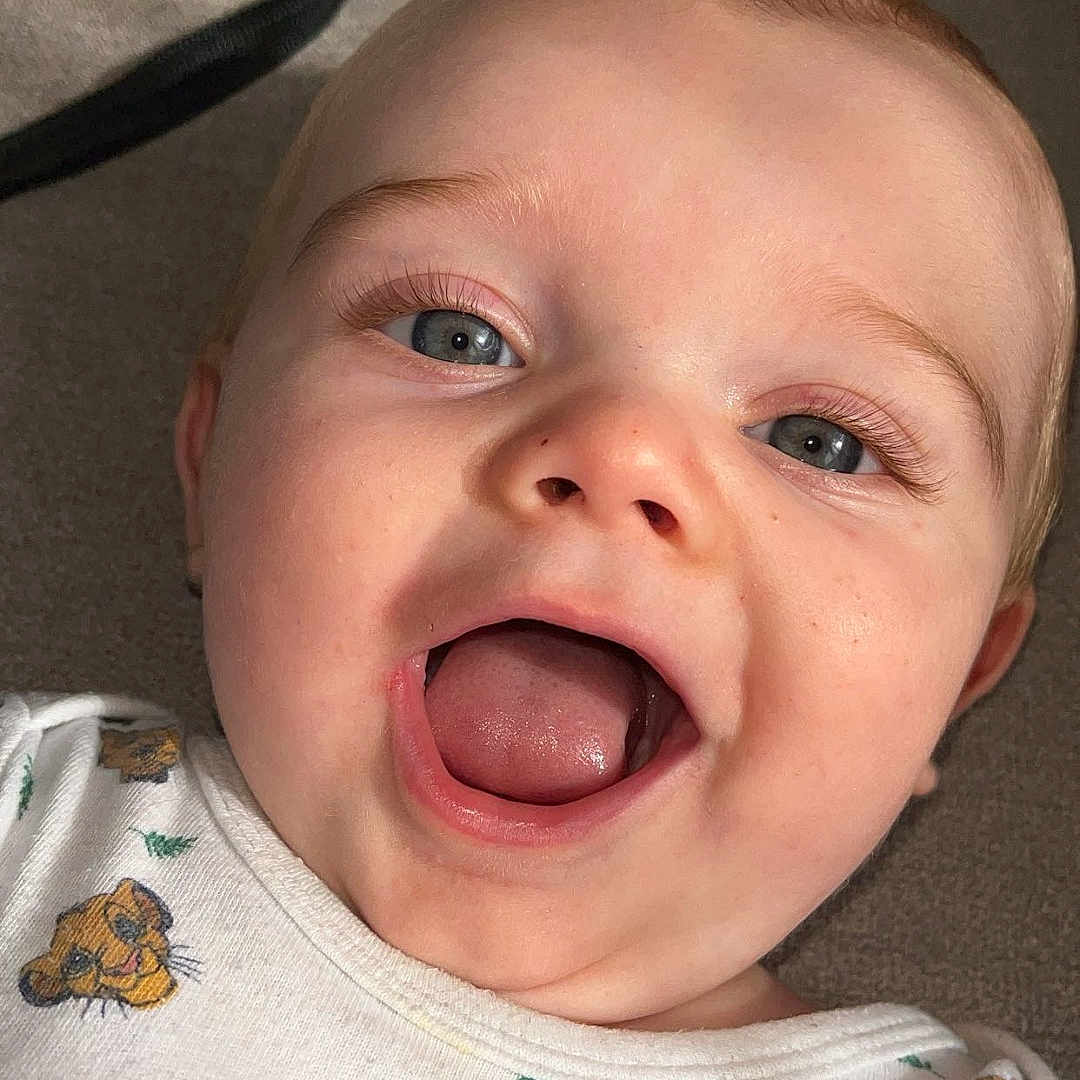 Milann a rejoint le concours — aidez-le/la à gagner de superbes lots ! animal_print, baby, blue_eyes, child, closeup, clothing, cute, eyelashes, face, happy, head, indoors, infant, lion_cub, mouth_open, pattern, portrait, skin, smiling, tongue