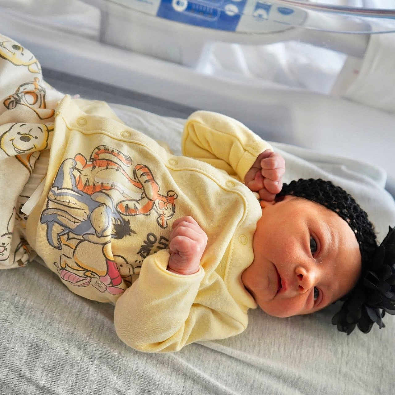 Melody is registered to the contest to win money with this photo: baby, baby_bed, baby_girl, blanket, cartoon_characters, clothing, cute, flower, headband, hospital_bed, indoors, infant, newborn, pajamas, person, portrait, resting, skin, sleeping, winnie_the_pooh