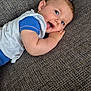 baby, blue_eyes, smiling, lying_down, couch, textured_fabric, infant, happy, child, close_up, casual_clothing, toddler, indoor, portrait, skin, face, hand, cute, young_child, relaxing