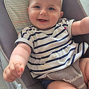 Aimée a rejoint le concours — aidez-le/la à gagner de superbes lots ! baby, child, smiling, happy, face, arm, legs, striped_shirt, baby_rocker, cushion, indoor, person, closeup, cute, infant, skin, blue_eyes, short_hair, happy_expression, reaching_hand