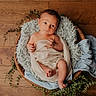 baby, newborn, infant, wooden_floor, wooden_bowl, blanket, fabric, greenery, plant, wrapped, sleepy, cute, indoor, soft_texture, peaceful, child, portrait, natural_light, relaxing, cozy