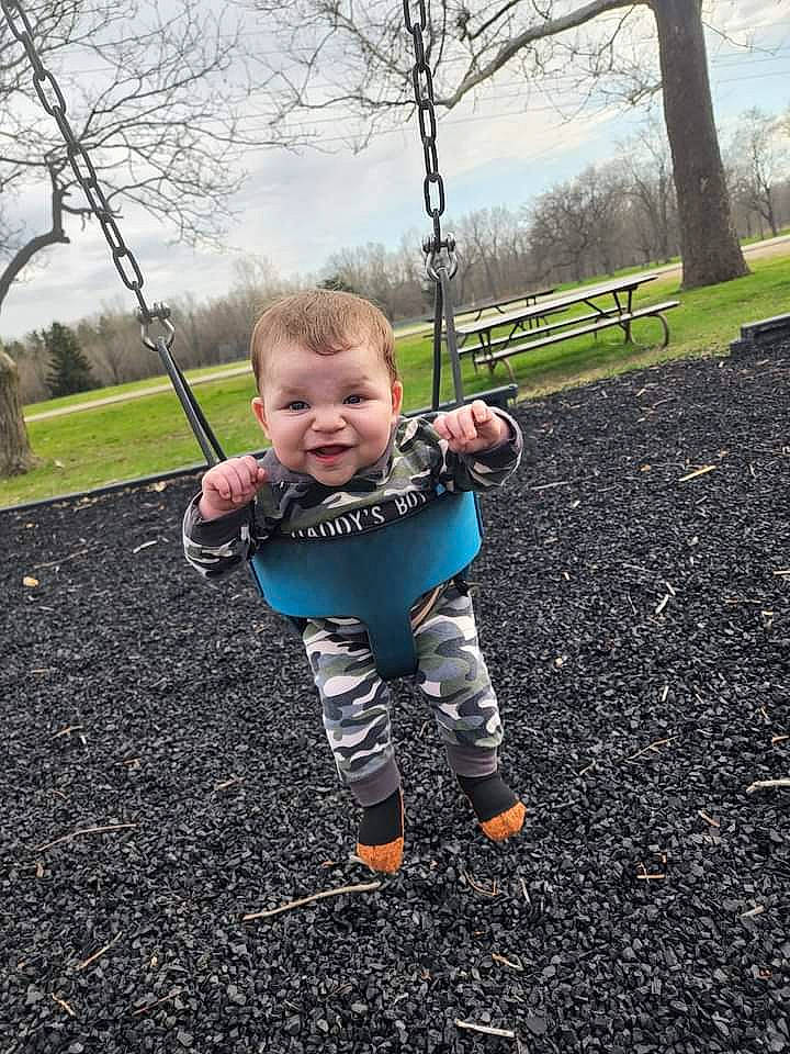 Auston is registered to the contest to win money with this photo: asphalt, baby, baby_toddler_clothing, cloud, eye, flash_photography, fun, grass, happy, leaf, people_in_nature, person, plant, playground, recreation, sky, sleeve, smile, swing, toddler