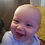 Mason is registered to the contest to win money with this photo: baby, smiling, close_up, face, infant, joyful, couch, pillow, indoor, happy, person, child, head, skin, eyes, mouth, clothing, human, portrait, expression