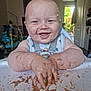 baby, high_chair, messy, chocolate, food, smiling, happy, indoor, child, face, arms, hands, pudding, feeding_time, home, daylight, toy, clothing, playful, infant