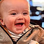 baby, smiling, happy, face, child, jacket, clothing, striped_shirt, closeup, portrait, indoor, cute, cheerful, young, infant, warm, soft_light, expression, human, joyful