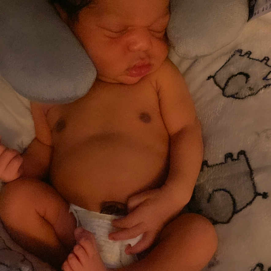 Jordyn Evans is registered to the contest to win money with this photo: baby, blanket, child, comfort, cozy, cute, diaper, face, foot, hand, indoors, infant, lying_down, neck_pillow, newborn, peaceful, rest, skin, sleeping, soft