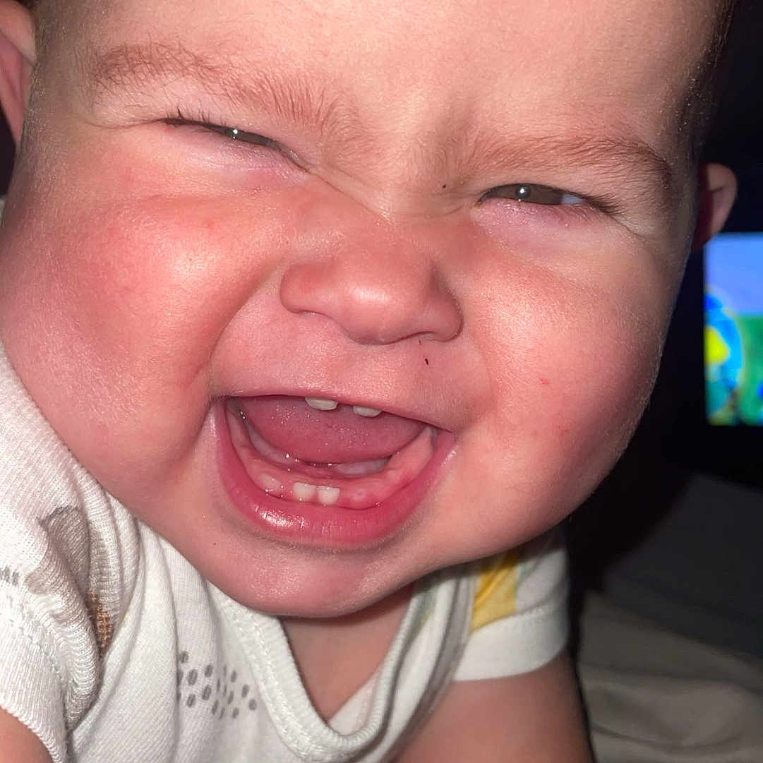 Saylor joined the competition — help win amazing prizes! arm, baby, babyclothes, candid, cheeks, child, closeup, expression, face, happy, head, human, indoor, infant, joy, onesie, person, skin, smiling, teeth