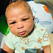 Alijah is registered to the contest to win money with this photo: baby, child, infant, face, onesie, milk, pillow, closeup, sunlight, expression, skin, seated, indoors, clothing, cute, portrait, young, person, head, babywear