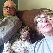Rodja participe au concours pour gagner de l'argent avec cette photo : man, woman, dog, glasses, couch, indoor, casual, pet, brown_couch, spotted_dog, relaxed, smile, beard, short_hair, sweater, portrait, home, comfort, cigarette, selfie