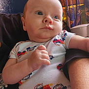 Eiron is registered to the contest to win money with this photo: baby, infant, newborn, onesie, blue_eyes, chubby_cheeks, hand, arm, adult_arm, close_up, portrait, indoor, curtain, vehicle_prints, clothing, soft_light, gaze, cute, family, skin_tone