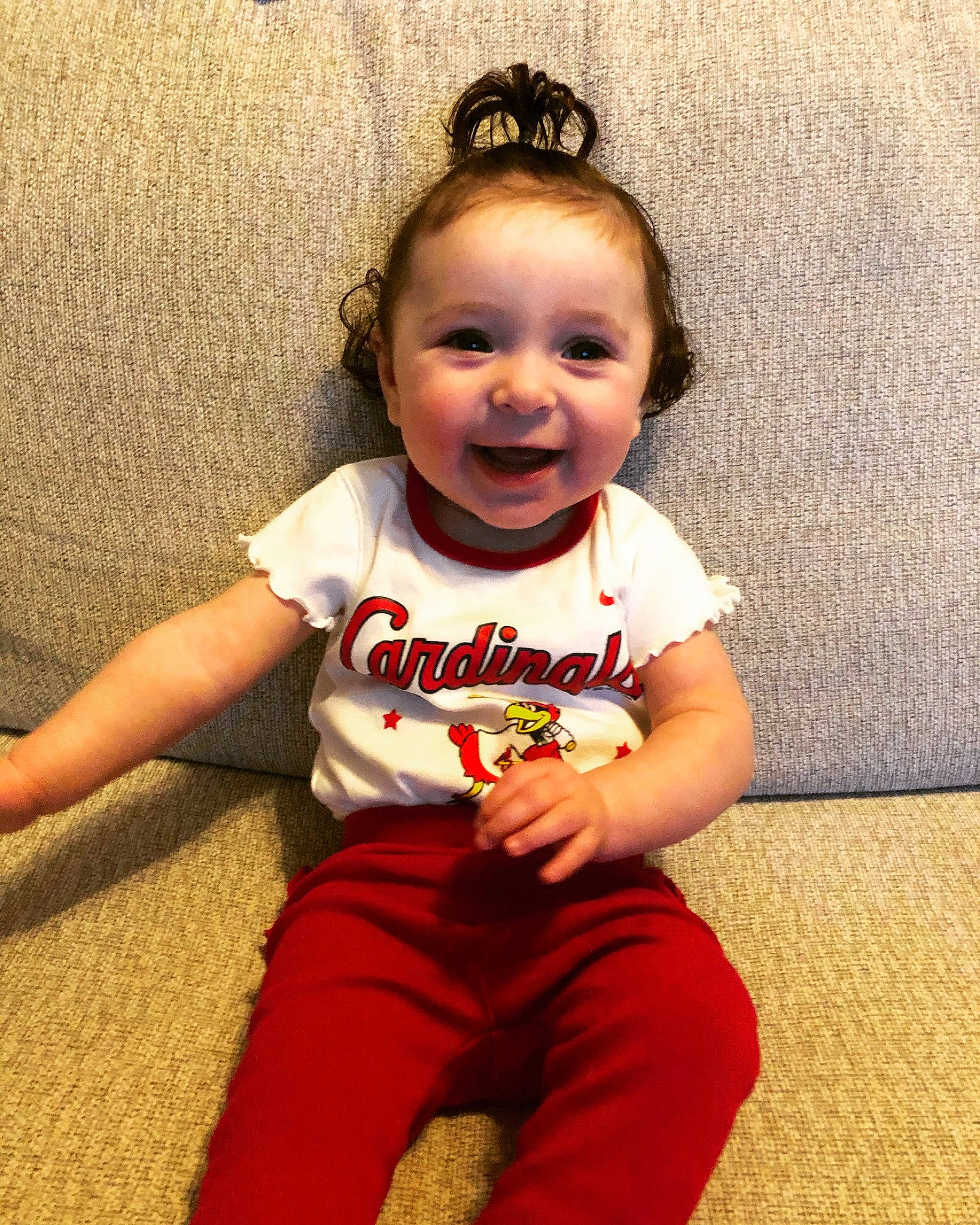 Clara is registered to the contest to win money with this photo: baby, baby_toddler_clothing, cheek, child, eye, flooring, fun, hair, happy, head, headband, human_body, human_leg, person, sitting, skin, sleeve, smile, standing, t_shirt