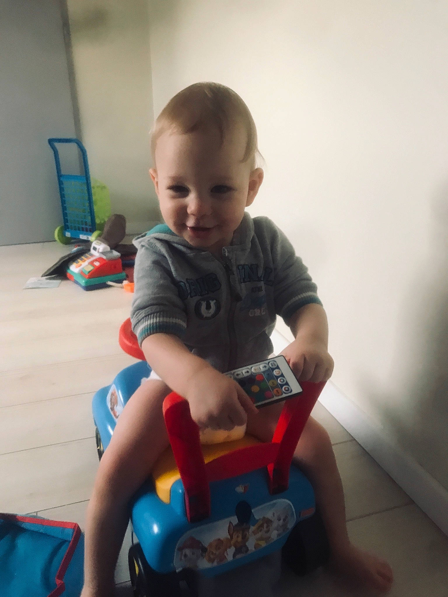 Kenzo a rejoint le concours — aidez-le/la à gagner de superbes lots ! baby, baby_playing_with_toys, baby_toddler_clothing, child, comfort, electric_blue, flooring, fun, happy, human_leg, joy, knee, person, play, riding_toy, sitting, smile, tire, toddler, toy