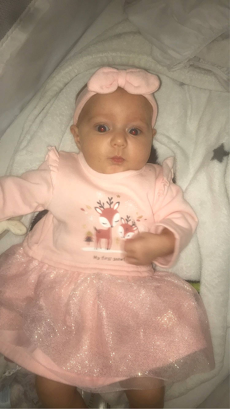Ilena participe au concours pour gagner de l'argent avec cette photo : baby, baby_products, baby_toddler_clothing, cheek, comfort, dress, embellishment, hand, head, headwear, human_body, iris, linens, lip, nose, peach, person, pink, ruffle, sitting