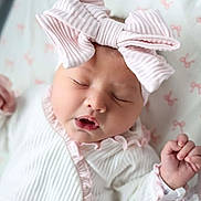 Oakley joined the competition — help win amazing prizes! baby, newborn, sleeping, portrait, pink, bow, headband, onesie, infant, face, hands, closed_eyes, peaceful, cute, nursery, blanket, crib, indoors, closeup, photography