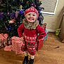 Piper is registered to the contest to win money with this photo: child, christmas_tree, holiday, presents, festive_clothing, red_dress, hat, smile, happy, indoors, boots, wooden_floor, decorations, lights, window_blinds, wrapped_gifts, cheerful, winter_fashion, holiday_season, family