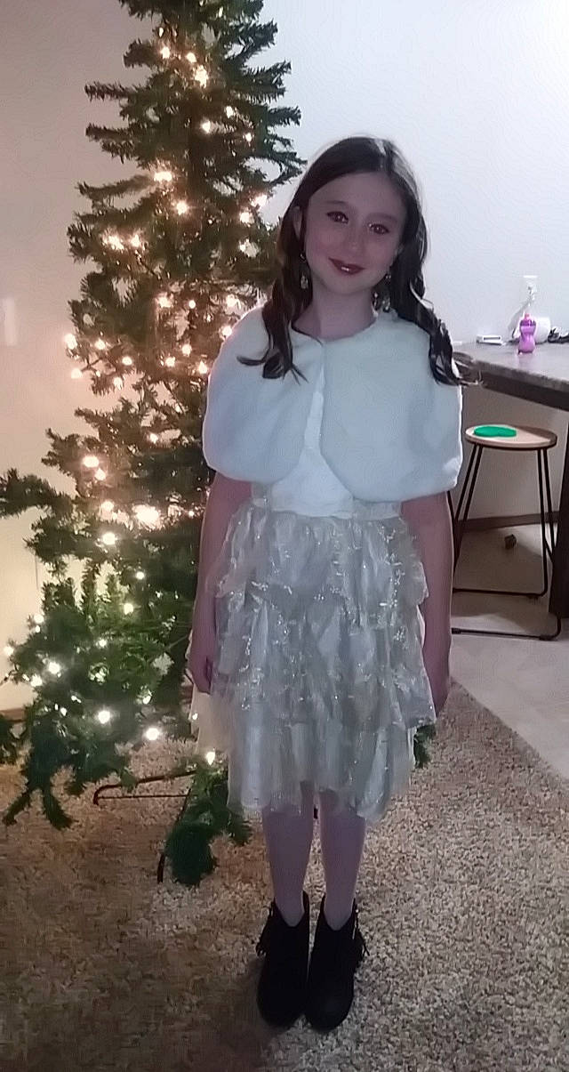 Ava joined the competition — help win amazing prizes! christmas_ornament, christmas_tree, dress, embellishment, evergreen, face, fashion_design, hair, happy, head, holiday_ornament, joy, knee, long_hair, ornament, person, sleeve, smile, standing, thigh