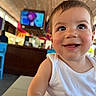 toddler, child, smiling, face, indoor, white_tank_top, happy, person, cheeky, eyes, skin, hair, table, furniture, television, blurred_background, colorful, expression, portrait, candid