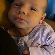 Milani is registered to the contest to win money with this photo: baby, newborn, infant, close_up, face, eyes, hand, onesie, purple_clothing, sleepwear, skin, cute, resting, portrait, child, person, indoors, soft_lighting, cozy, newborn_clothing