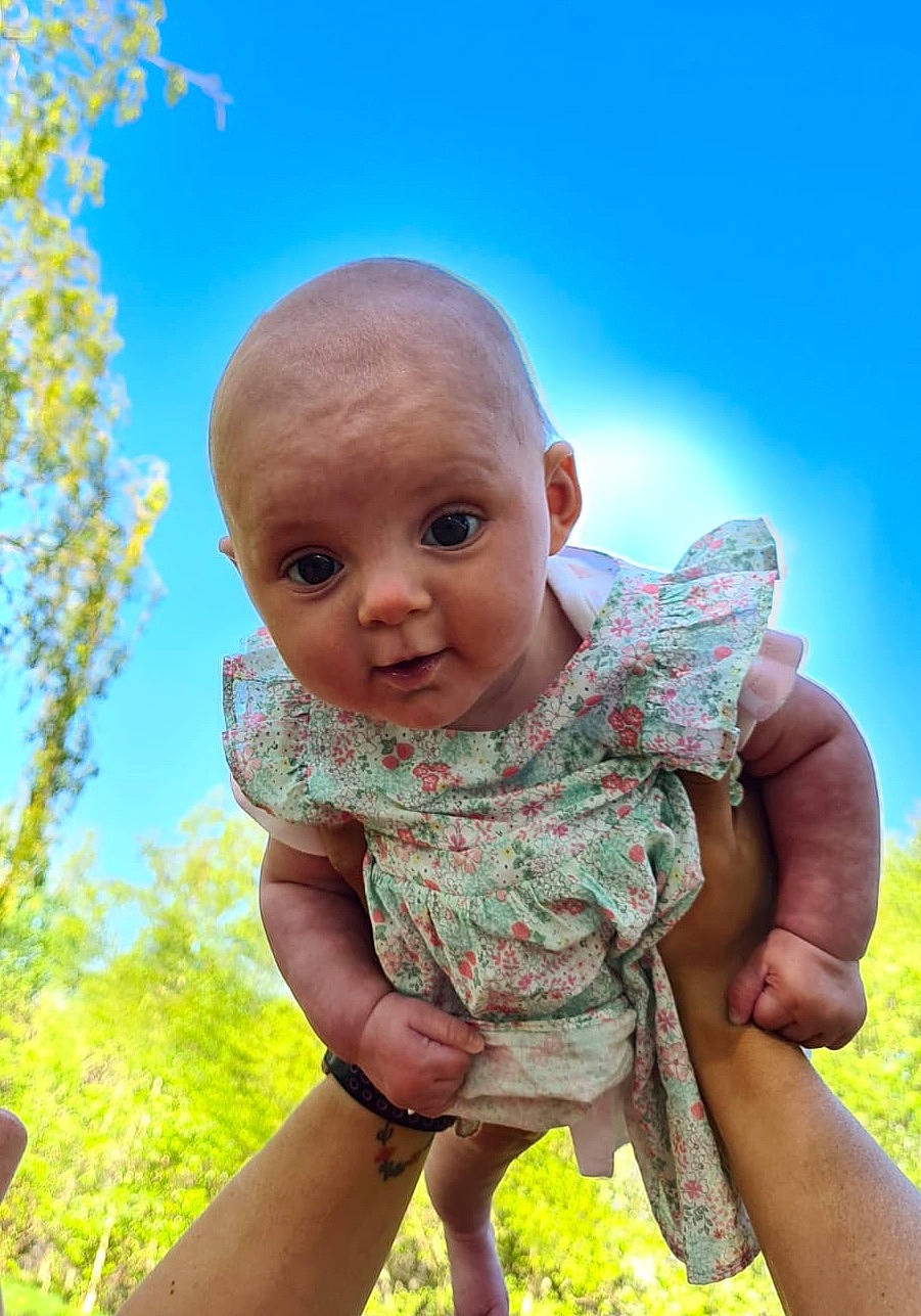 India is registered to the contest to win money with this photo: adaptation, baby, child, face, fun, grass, green, hand, happy, head, nose, person, sitting, skin, smile, summer, toddler