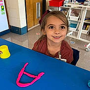 Sydney is registered to the contest to win money with this photo: child, clothing, desk, face, female, furniture, girl, happy, head, number, person, photography, portrait, sleeve, smile, stethoscope, student, symbol, table, text