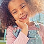 Maya participe au concours pour gagner de l'argent avec cette photo : child, girl, smiling, curly_hair, denim_overalls, pink_shirt, outdoor, sunlight, portrait, happy, face, hand, nature, daylight, cute, fashion, childhood, young, casual, blurry_background