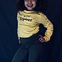 Maya a rejoint le concours — aidez-le/la à gagner de superbes lots ! child, smiling, curly_hair, yellow_shirt, pants, posing, standing, indoor, portrait, happy, fashion, dark_background, casual_clothing, black_shoes, hands_on_hips, cute, person, young, confident, full_body