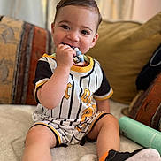 Ilham participe au concours pour gagner de l'argent avec cette photo : baby, blanket, child, clothing, couch, cushion, cute, face, footwear, hand, happy, home, indoor, person, portrait, sitting, smiling, sneakers, teething_toy, toddler