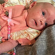 Freya is registered to the contest to win money with this photo: baby, infant, face, headband, clothing, fabric, beads, pacifier_clip, closeup, skin, person, child, lying_down, pink, texture, cute, newborn, soft_lighting, apparel, resting