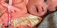 Freya is registered to the contest to win money with this photo: apparel, baby, beads, child, closeup, clothing, cute, fabric, face, headband, infant, lying_down, newborn, pacifier_clip, person, pink, resting, skin, soft_lighting, texture