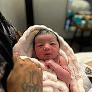 Mikiyo is registered to the contest to win money with this photo: newborn, baby, blanket, tattoo, hand, skin, face, infant, soft, cozy, wrapped, person, portrait, indoors, cute, sleepy, gentle, warm, human, newborn_baby