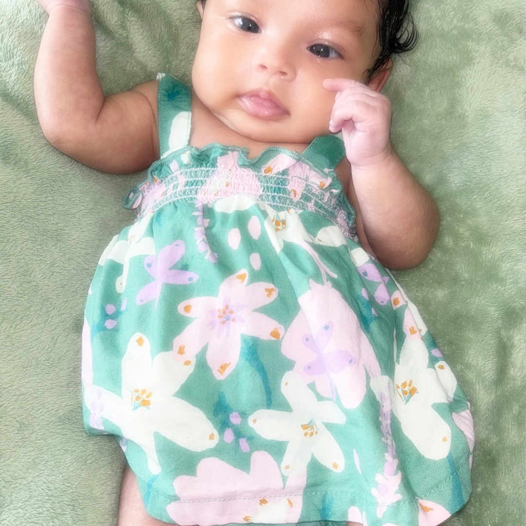 Solar is registered to the contest to win money with this photo: baby, infant, child, blanket, green, dress, floral, bow, cute, lying_down, soft_texture, indoors, skin, face, legs, arms, adorable, portrait, young, happy