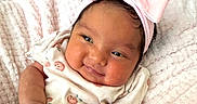 Solar is registered to the contest to win money with this photo: baby, blanket, child, chubby_cheeks, clothing, cute, face, fruit_prints, hand, happy, headband, human, infant, lying_down, newborn, pink_bow, portrait, skin, smile, soft_texture