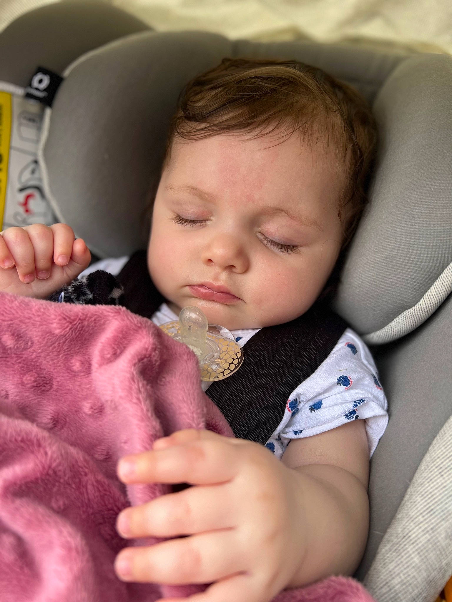 Emma participe au concours pour gagner de l'argent avec cette photo : baby, baby_toddler_clothing, car_seat, cheek, chin, comfort, eyebrow, eyelash, facial_expression, gesture, hand, iris, lip, nail, neck, nose, person, seat_belt, skin, thumb