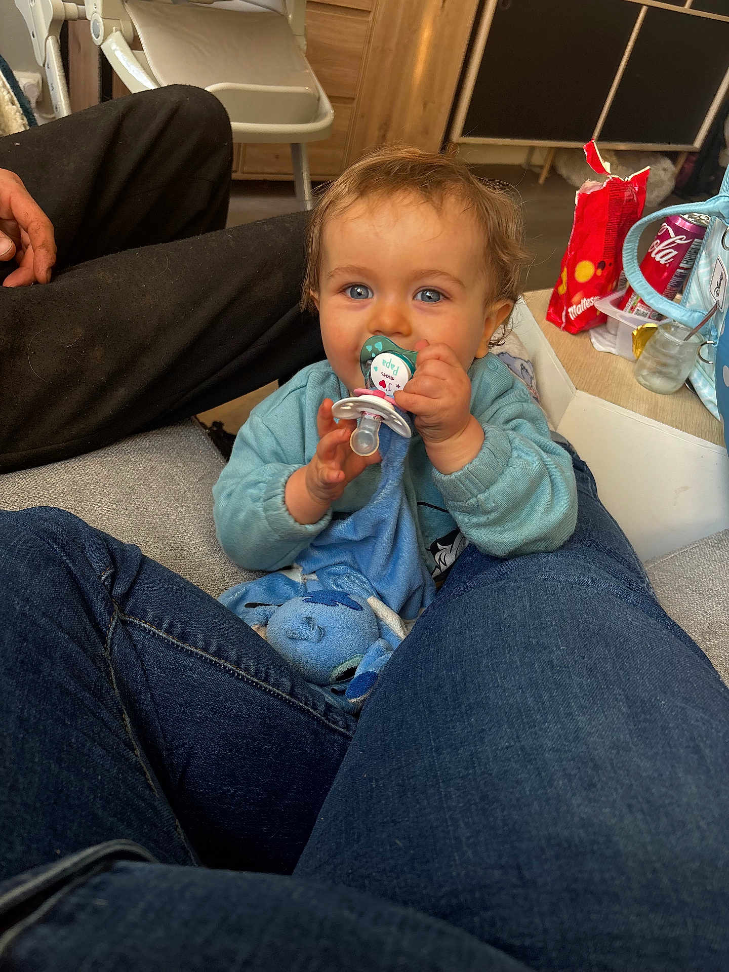 Naëlyo participe au concours pour gagner de l'argent avec cette photo : baby, pacifier, blue_eyes, plush_toy, jeans, indoor, candid, snacks, soda_can, hand, furniture, floor, wood, casual, clothing, person, child, seated, comfort, home