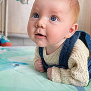Marceau a rejoint le concours — aidez-le/la à gagner de superbes lots ! baby, child, blue_eyes, red_hair, denim_overalls, cream_sweater, blanket, bed, indoor, cute, infant, portrait, closeup, soft_lighting, curious, young_child, baby_face, toddler, cozy, home