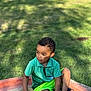 Idris a rejoint le concours — aidez-le/la à gagner de superbes lots ! child, boy, green_shorts, green_polo_shirt, golf_balls, concrete_bench, grass, outdoor, sunlight, shadows, curly_hair, sandals, park, playing, casual_clothing, sitting, daytime, nature, recreation, young_person