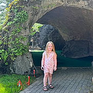 Brynlee Mae is registered to the contest to win money with this photo: child, girl, grass, greenery, leaves, mini_golf, nature, outdoor, pathway, pink_clothing, playing, putting_green, recreation, rock_formation, sandals, smiling, summer, sunlight, trees, vine