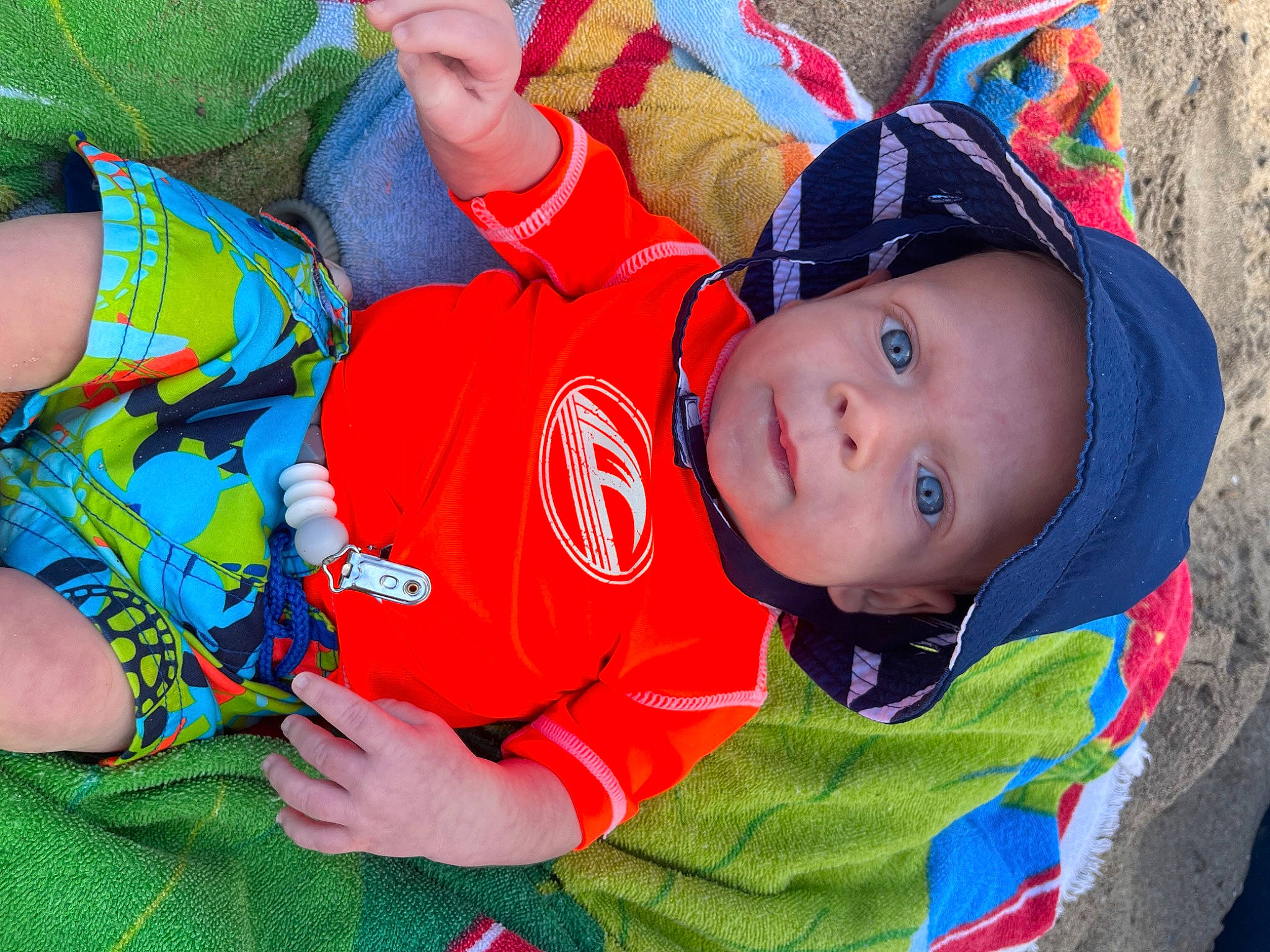 Kip is registered to the contest to win money with this photo: baby, baby_toddler_clothing, cap, child, electric_blue, fun, grass, green, happy, hat, headwear, jacket, leisure, pattern, person, plant, play, recreation, sitting, toddler