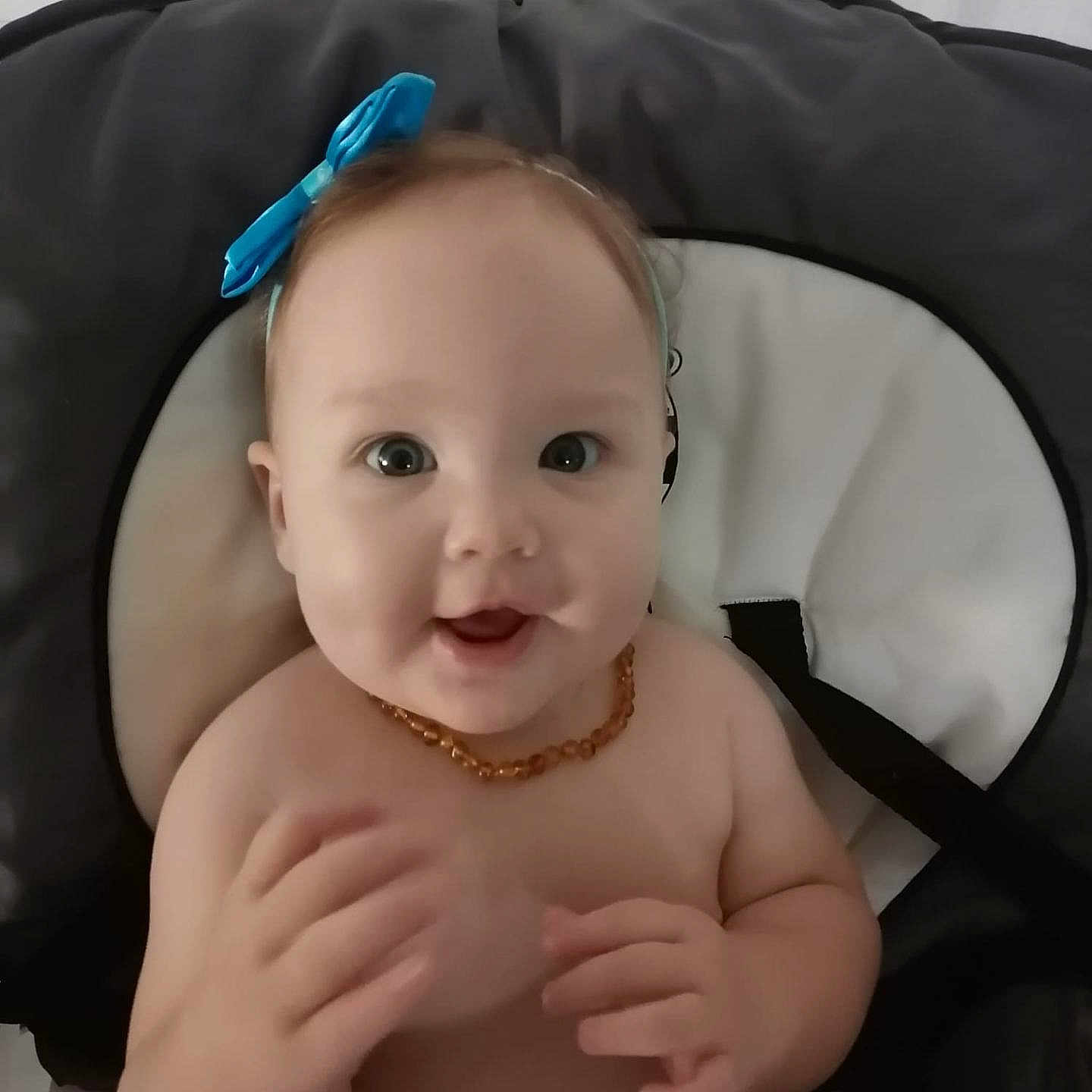 Soélia a rejoint le concours — aidez-le/la à gagner de superbes lots ! baby, bare_chest, blue_bow, bright_eyes, child, comfort, cushioned_seat, cute, face, hand, happy, headband, indoors, infant, joy, necklace, person, seat, smile, young