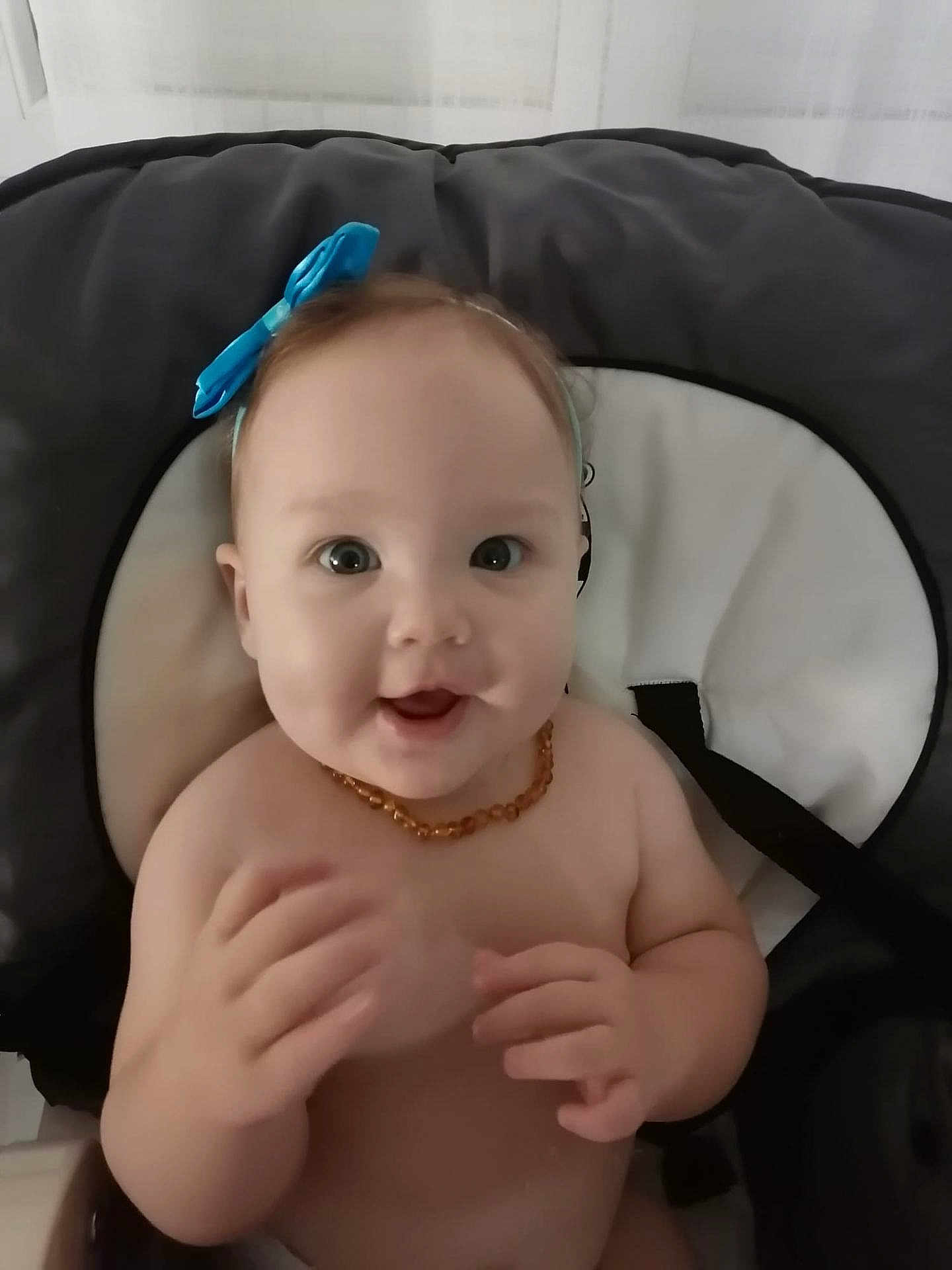 Soélia a rejoint le concours — aidez-le/la à gagner de superbes lots ! baby, child, smile, blue_bow, headband, cushioned_seat, happy, indoors, infant, bare_chest, necklace, hand, face, person, cute, young, bright_eyes, seat, comfort, joy