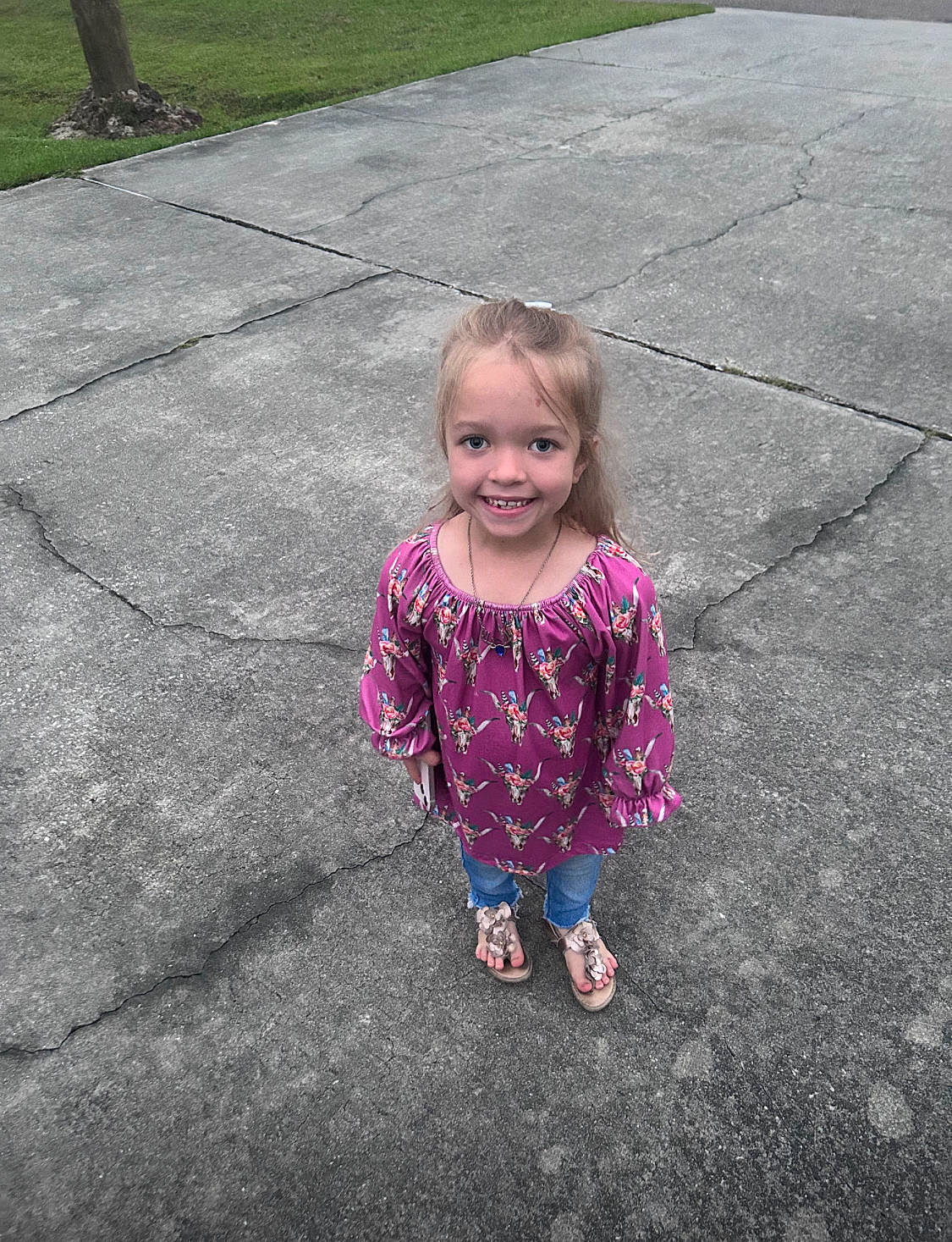 Hannah is registered to the contest to win money with this photo: asphalt, baby_toddler_clothing, child, fun, grass, hairstyle, head, joy, leaf, leisure, magenta, people_in_nature, person, pink, plant, purple, recreation, road_surface, sidewalk, smile