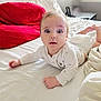 baby, infant, bed, pillow, red_pillow, white_sheets, diaper, onesie, wide_eyes, face, hands, blanket, indoor, mattress, cute, looking_at_camera, portrait, sleepwear, room, nursery