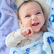 Blake is registered to the contest to win money with this photo: baby, infant, smiling, blanket, blue_blanket, bedding, plush, pajamas, face, eyes, hand, dimples, hair, cozy, portrait, close_up, newborn, cute, lying_down, nursery