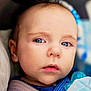 baby, infant, blue_eyes, close_up, portrait, face, pacifier, blanket, car_seat, seatbelt, clothing, skin, eyelashes, lips, nose, cheek, head, expression_neutral, soft_lighting, indoor