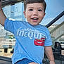 Battistu a rejoint le concours — aidez-le/la à gagner de superbes lots ! toddler, child, smiling, blue_shirt, lightning_mcqueen, shorts, outdoor, playful, happy, face, person, window, reflection, storefront, daylight, arm, leg, expression, casual_clothing, young