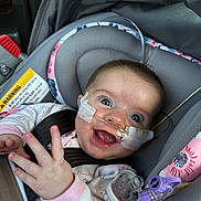 Jaylee joined the competition — help win amazing prizes! baby, infant, car_seat, smiling, medical_tube, nasal_cannula, happy, child, seat_belt, clothing, indoors, portrait, face, head_support, pink, toy, hand, eyes, healthcare, cute