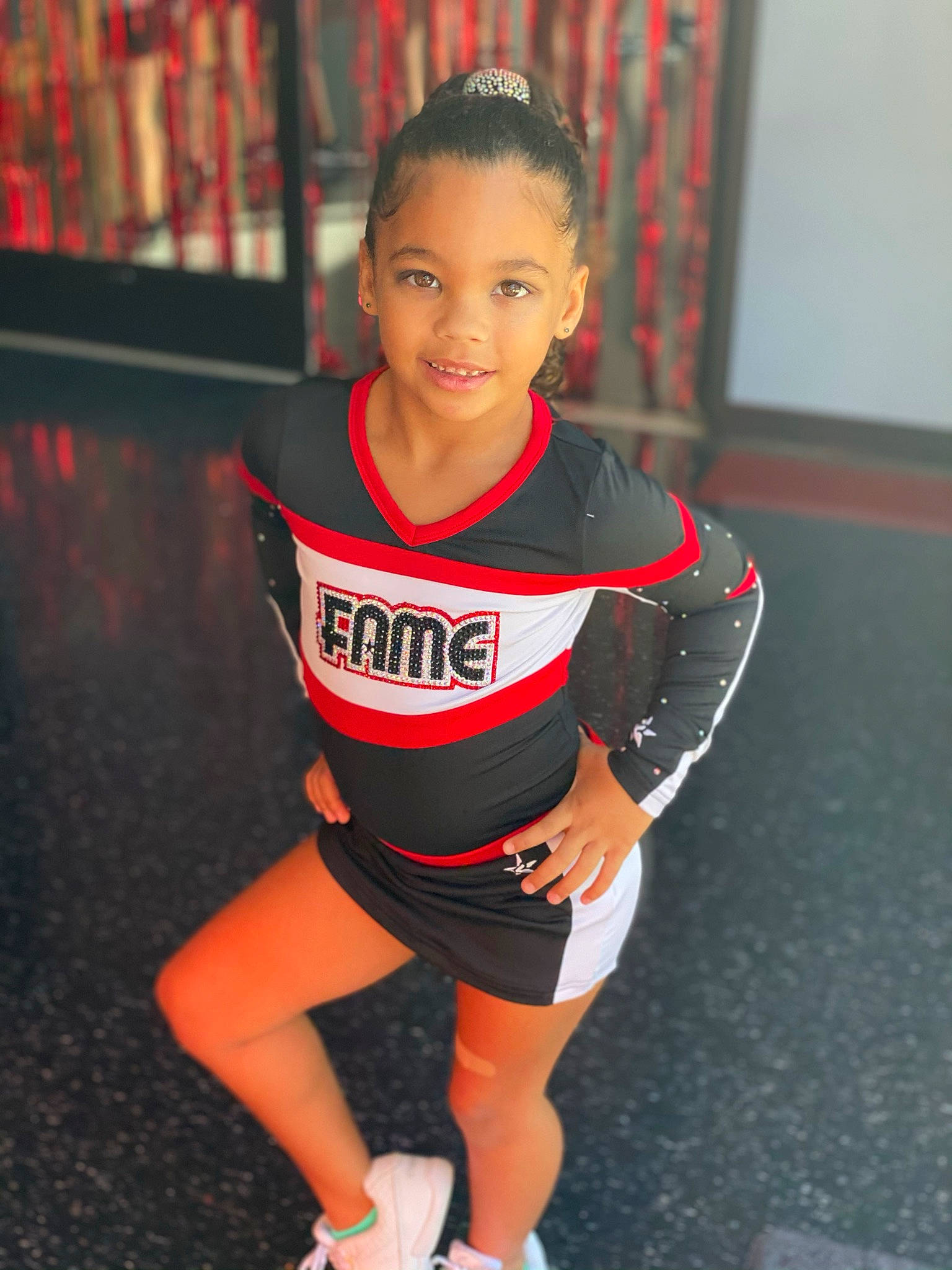 Penelope is registered to the contest to win money with this photo: cheerleading_uniform, face, flash_photography, flooring, hair, human_leg, jersey, joy, knee, long_hair, neck, person, player, shoulder, sleeve, smile, sports_uniform, sportswear, t_shirt, thigh