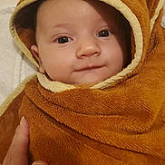 Robin participe au concours pour gagner de l'argent avec cette photo : baby, child, towel, hooded_towel, brown, soft_texture, face, eyes, smile, hand, cute, infant, portrait, wrapped, warm, indoor, person, newborn, cozy, baby_clothing